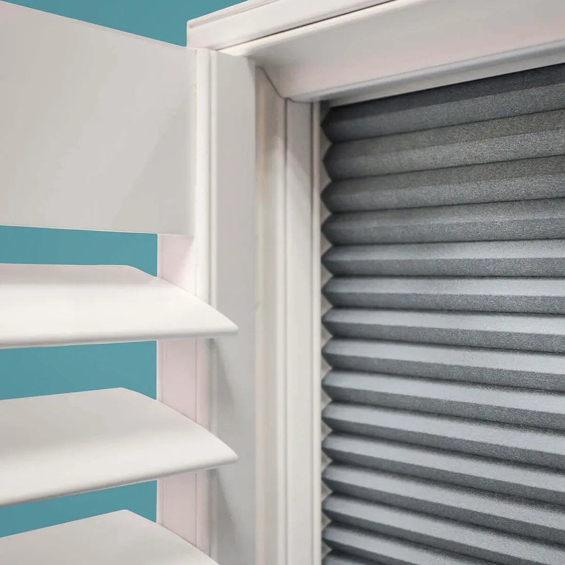A blackout blind drawn down behind an open white shutter panel