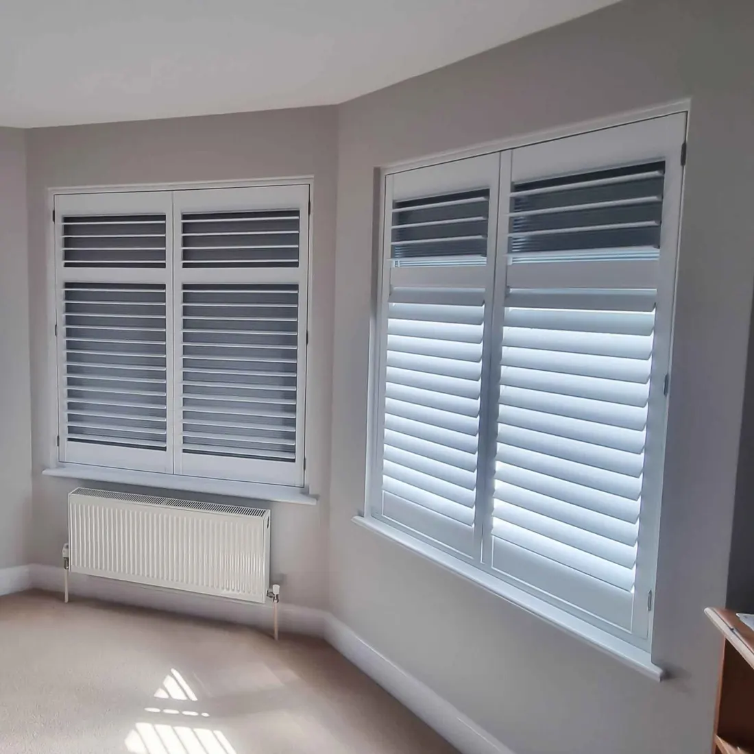 Grey shutters with blackout blinds on two corner windows