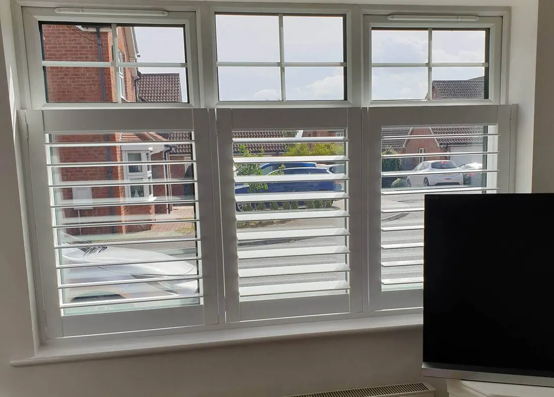 Café style white shutters on a front room window with small panes above