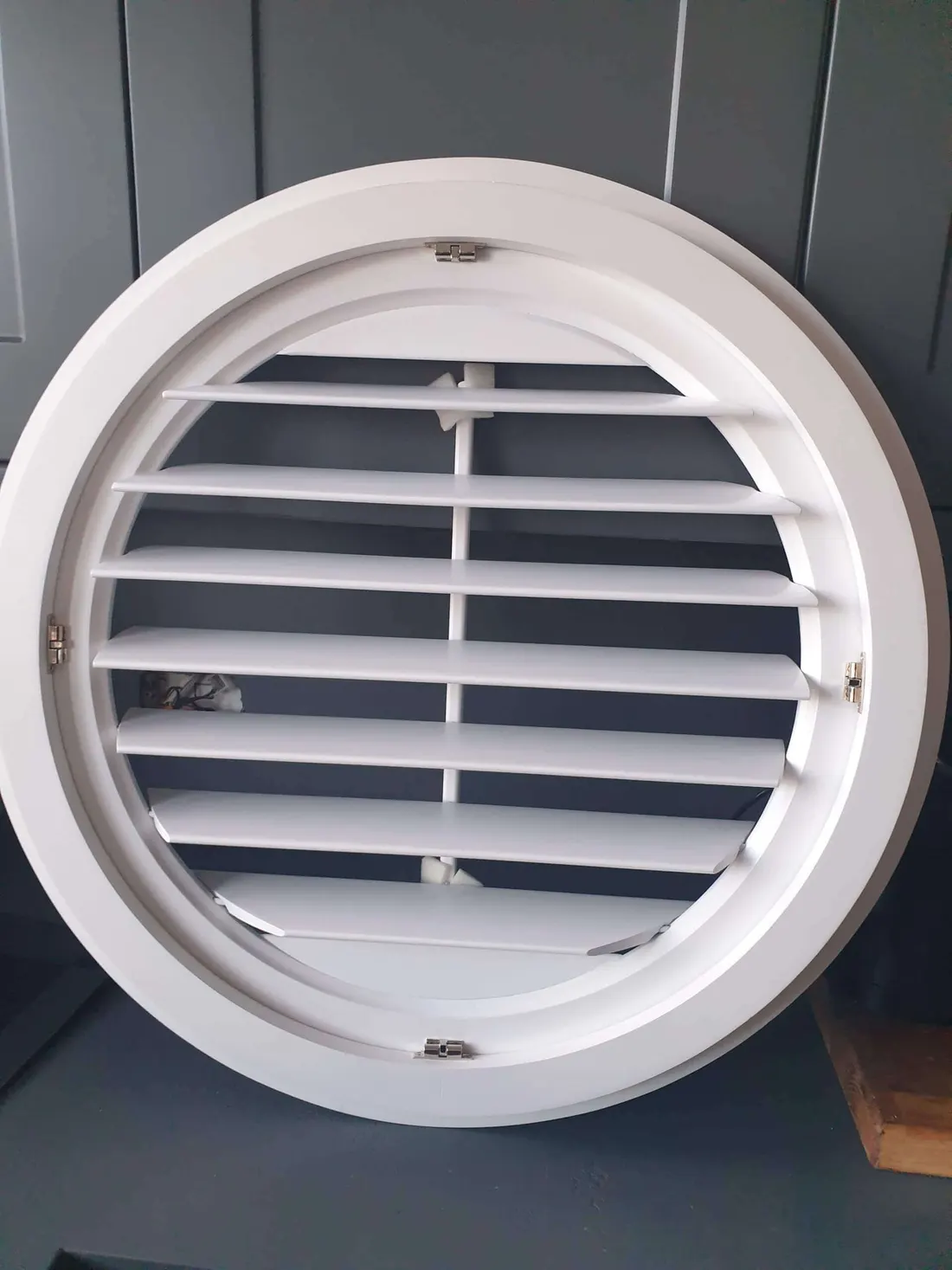 Close view of a round white shutter with its louvres open